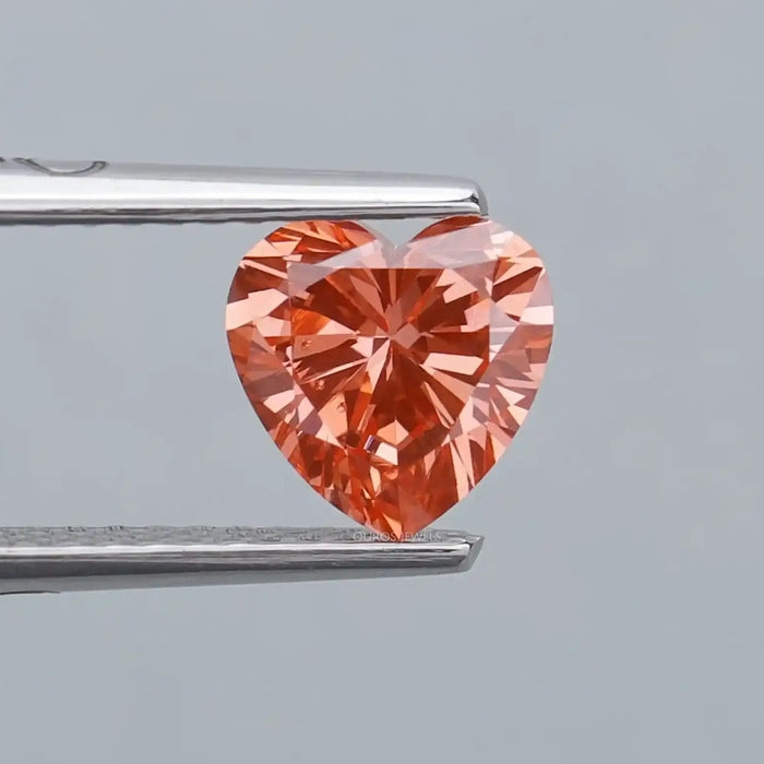 0.90ct vivid pink heart shaped lab grown diamond loose held with tweezer