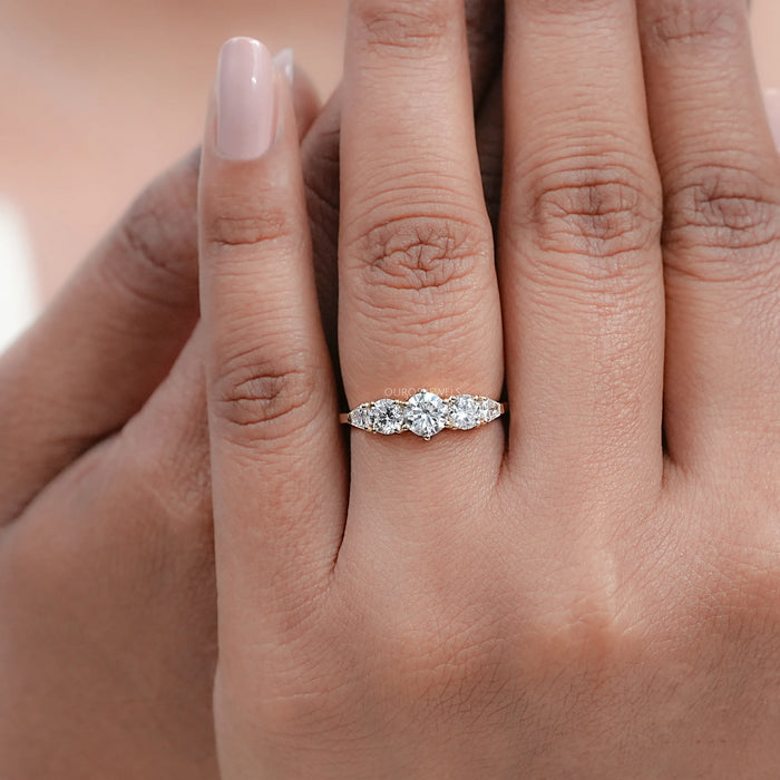 round and shield cut lab diamond five stone engagement ring on model's finger