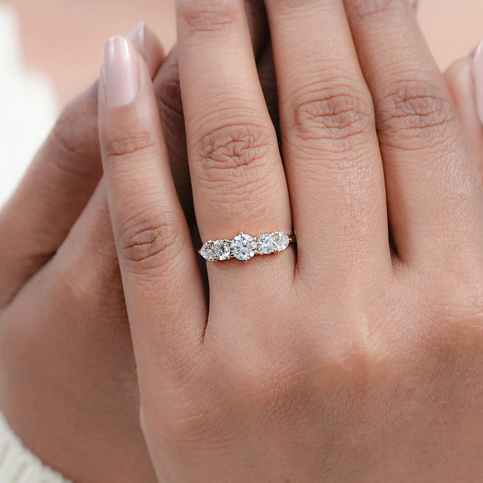 round and heart cut lab diamond five stone engagement ring in finger