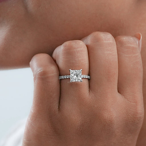 front view of princess cut diamond solitaire accent engagement ring on model's finger