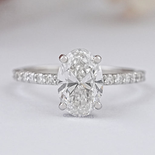 front view of oval-shaped diamond solitaire accent engagement ring on grey fabric