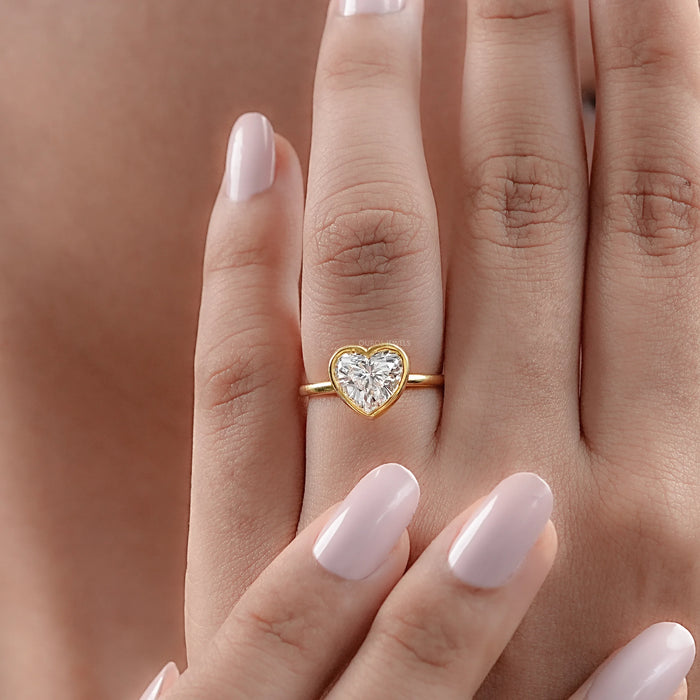 heart-shape diamond bezel set solitaire engagement ring in finger