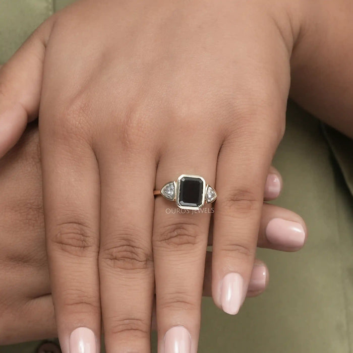 emerald gemstone bezel set engagement ring with trillion cut lab diamonds