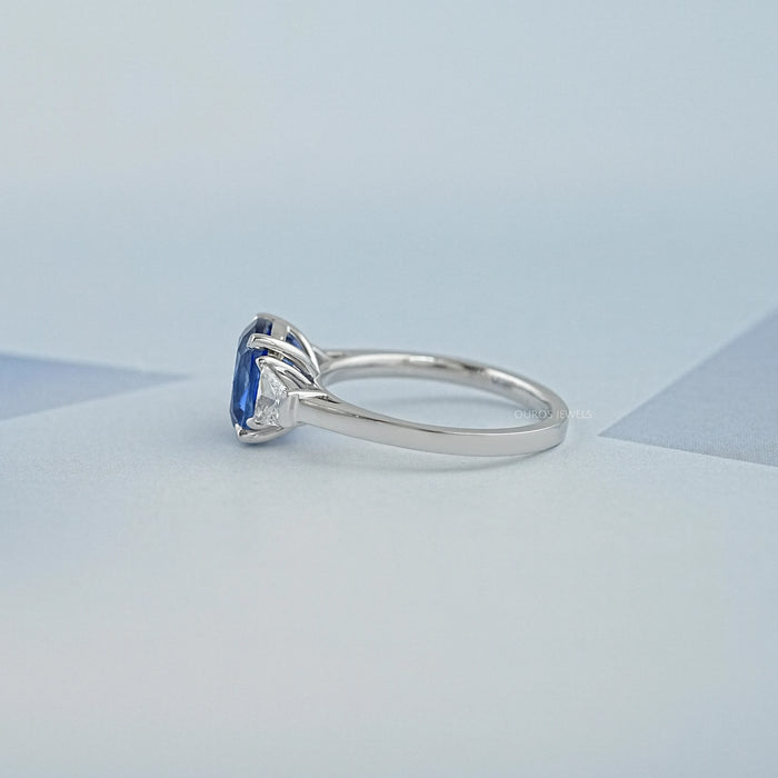 side view of sapphire cushion gemstone with trapezoid diamond 3 stone wedding ring