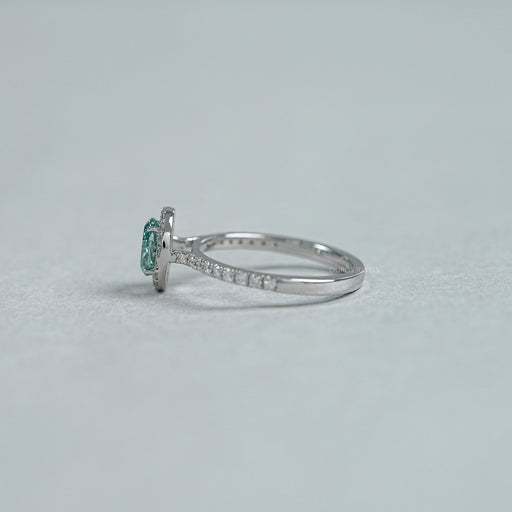 side view of fancy vivid green oval cut diamond halo wedding ring on grey fabric