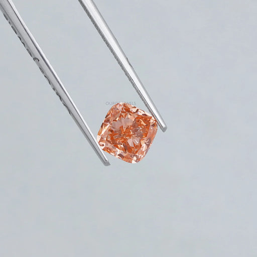 1.35 carat pink cushion cut lab created diamond loose held with tweezer