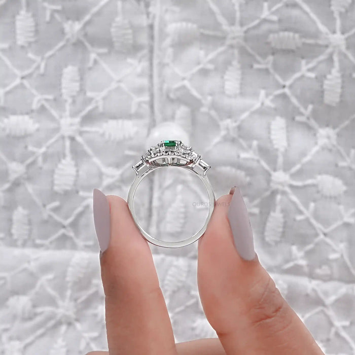 emerald gemstone featuring halo of baguette and round diamonds 