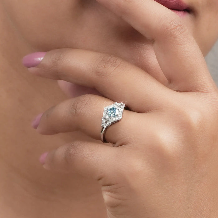 A Women showing 3 Stone Blue Hexagon Side Diamond Ring 