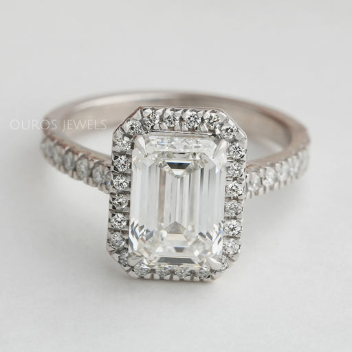 emerald cut lab diamond halo engagement ring's front angle view on grey fabric