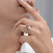 pink emerald diamond three-stone hidden halo colored engagement ring on model's finger