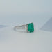 side view of green emerald gemstone pear diamond three stone engagement ring