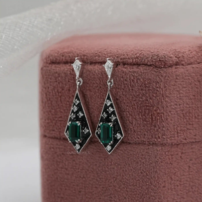 kite shape diamond drop earrings hanging on soft jewel box