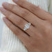emerald and baguette cut lab diamond five stone engagement ring on model's finger