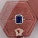blue gemstone halo ring kept on the soft ring box