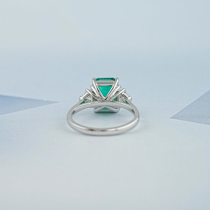 back view of green emerald gemstone with shield cut diamond 3 stone engagement ring