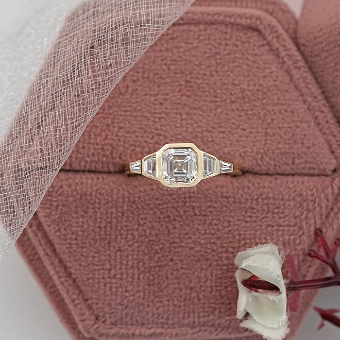 asscher and trapezoid cut lab diamond bezel five stone wedding ring in jewelry box