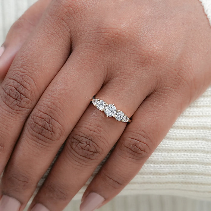 round and shield cut lab diamond five stone engagement ring in finger