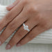 emerald cut and round lab diamond five stone engagement ring in finger