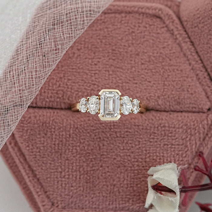 emerald and oval cut diamond half bezel five stone engagement ring in jewelry box