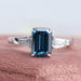 front view of blue emerald cut lab diamond three stone engagement ring