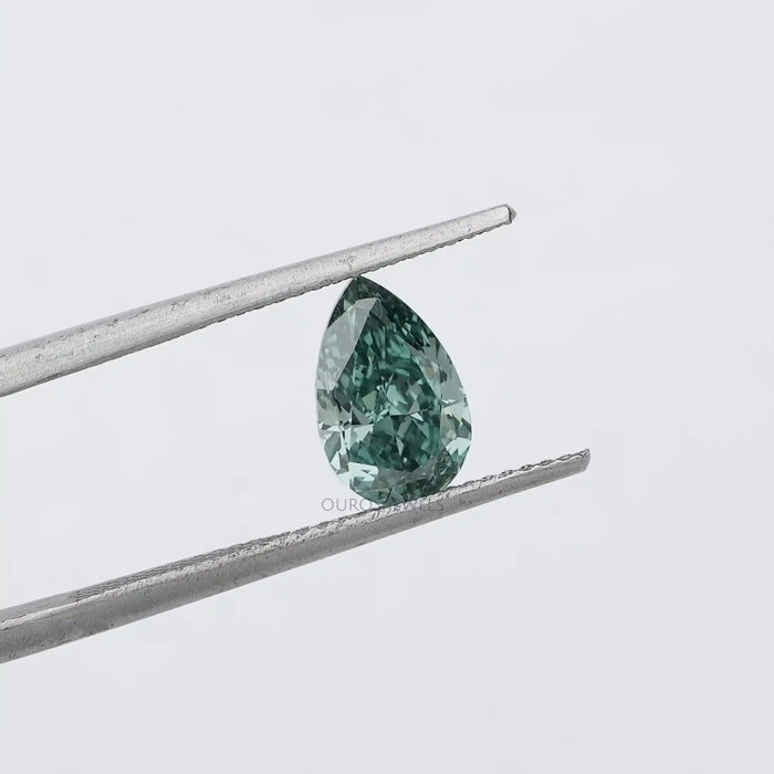 1.62 Carat Fancy Vivid Green Pear Cut Lab Grown Diamond hold by metal tweezers against a plain white background, highlighting its vivid green color and pear shape.