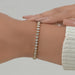 heart cut lab manufatured diamonds bezel set tennis bracelet in yellow gold on hand