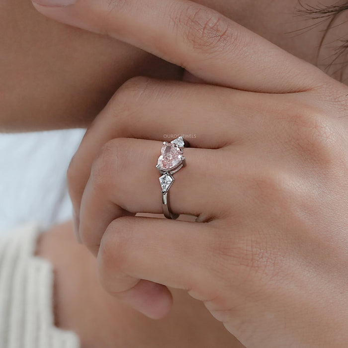 fancy pink heart cut lab diamond 3 stone engagement ring on model's finger