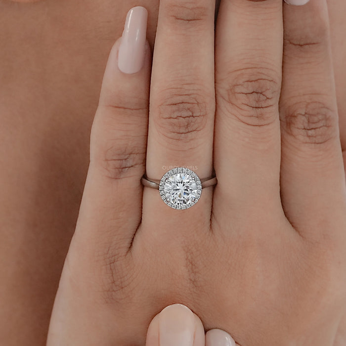 round brilliant cut lab diamond halo engagement ring in finger