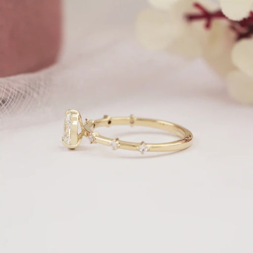 side view of pear-cut diamond solitaire accent wedding ring with yellow gold band