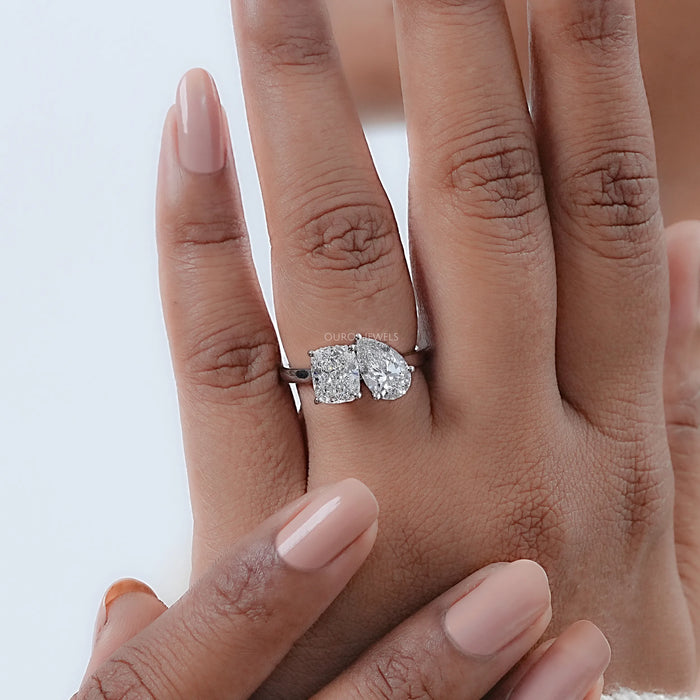 pear and cushion-cut diamond hidden halo toi et moi engagement ring on model's finger