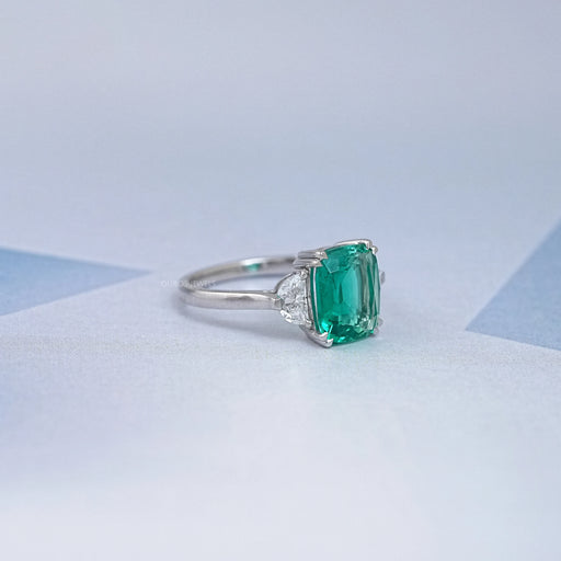 side view of green cushion and half moon cut diamond three stone engagement ring