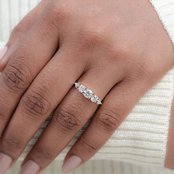 round and kite cut lab diamond five stone engagement ring in finger