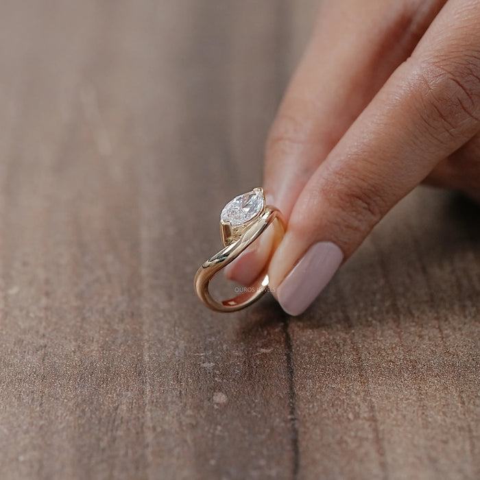 side view of marquise cut lab diamond wave engagement ring in yellow gold