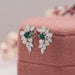 emerald gemstone and cluster diamond earrings