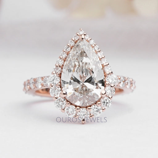 top view of pear cut lab diamond halo engagement ring in rose gold band