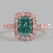 top view of green radiant cut diamond with pink diamond halo engagement ring
