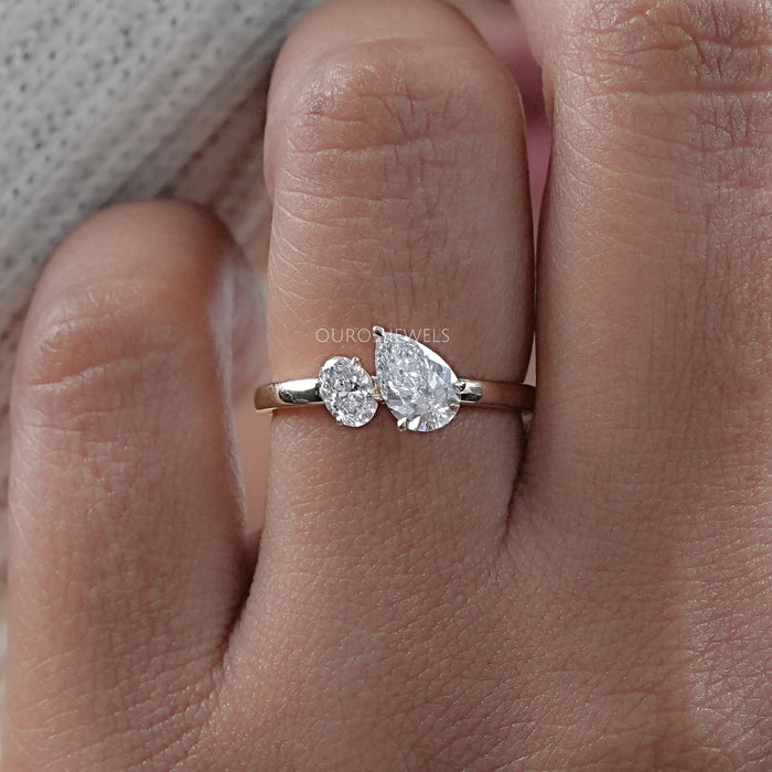 front view of oval and pear cut lab diamond toi et moi engagement ring in finger
