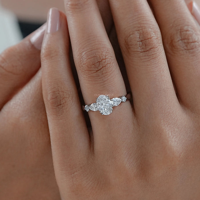 oval and pear cut lab diamond five stone engagement ring on model's finger