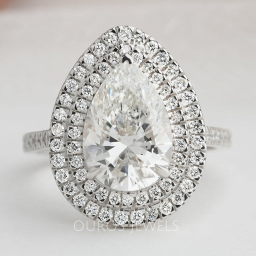 pear cut lab diamond double halo engagement ring's front view on grey fabric