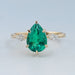 front view of green pear gemstone and kite cut diamond three stone engagement ring