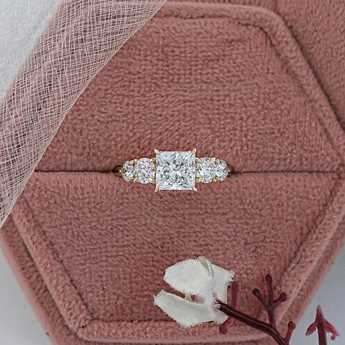 princess cut diamond five stone engagement ring in yellow gold band is in jewelry box