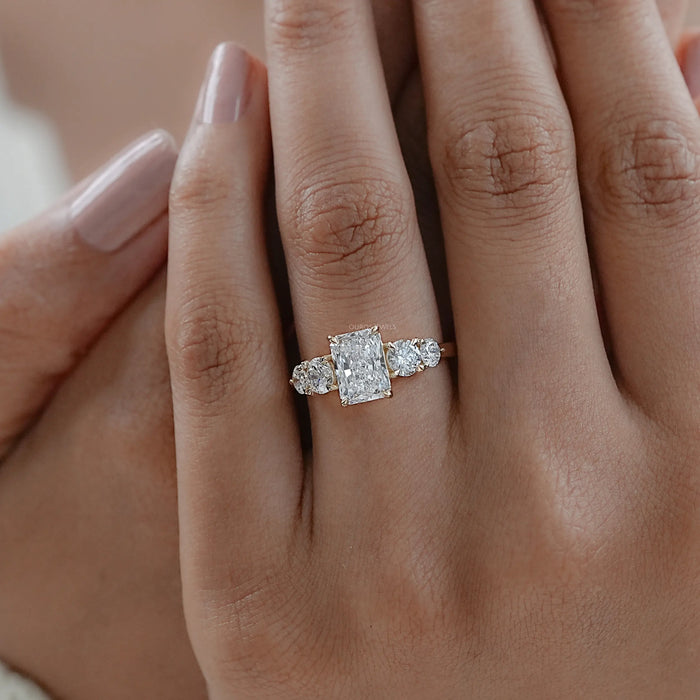 radiant cut lab grown diamond five stone engagement ring in finger