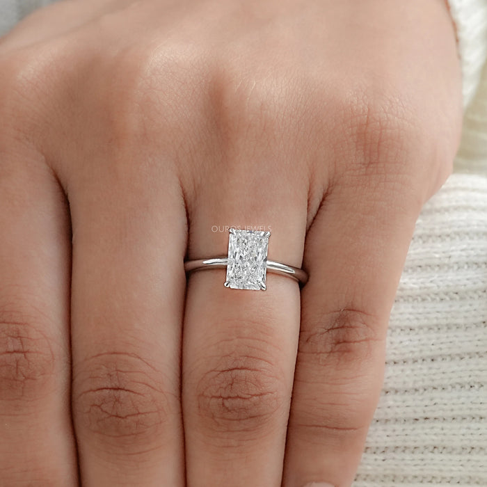 radiant cut diamond solitaire engagement ring in finger