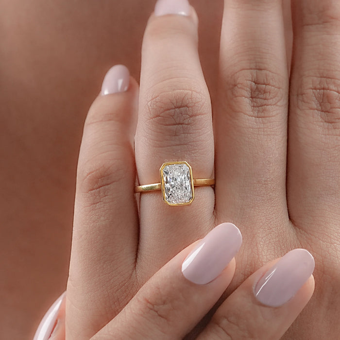 radiant cut lab diamond bezel set engagement ring in finger