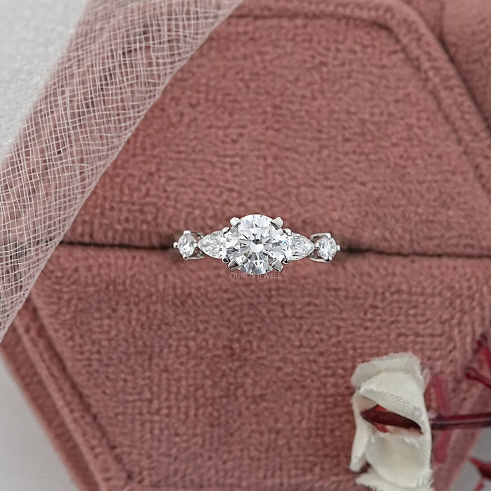 round and pear cut lab diamond five stone engagement ring in jewelry box