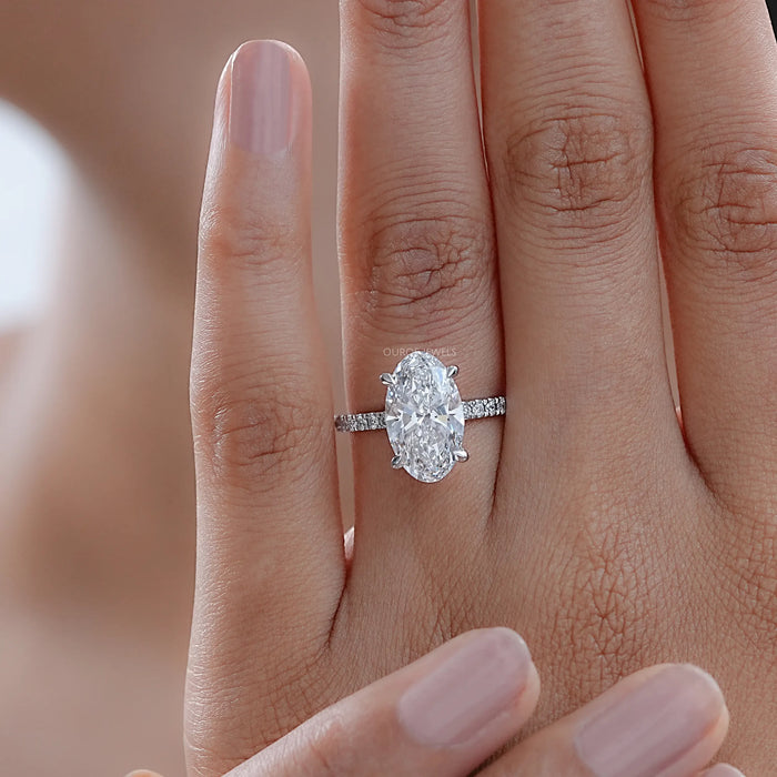 oval-cut lab grown diamond solitaire accent engagement ring on model's finger