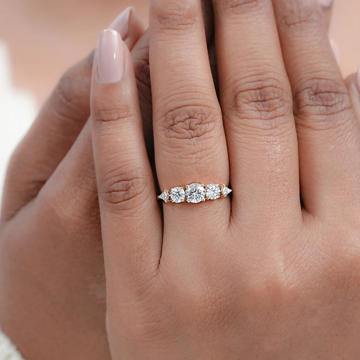 round and kite cut lab diamond five stone engagement ring on model's finger