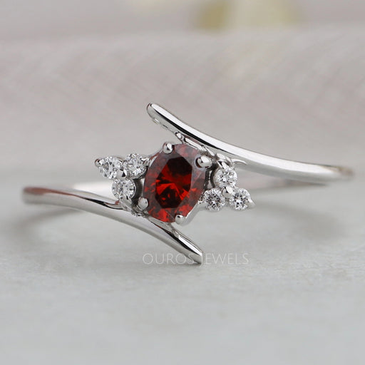 front view of red oval-cut lab-grown diamond bypass colored wedding band