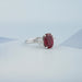 side view of oval ruby gemstone and half moon diamond 3 stone engagement ring