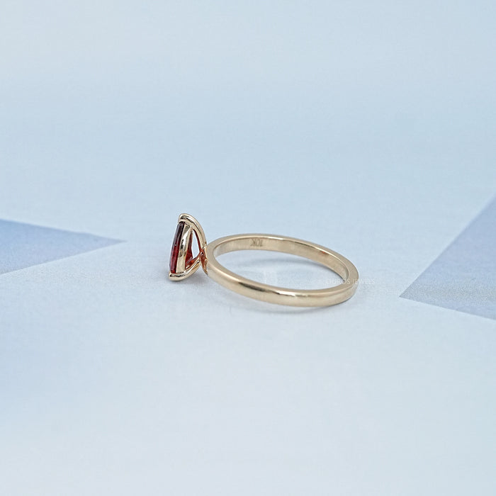 side view of garnet pear-cut gemstone solitaire engagement ring